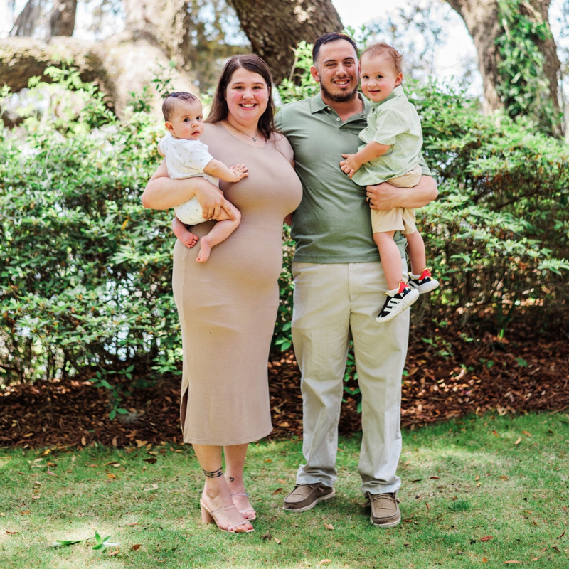 happy family smiling with two small children 